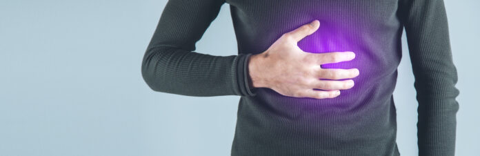man hand in ache stomache on gray background
